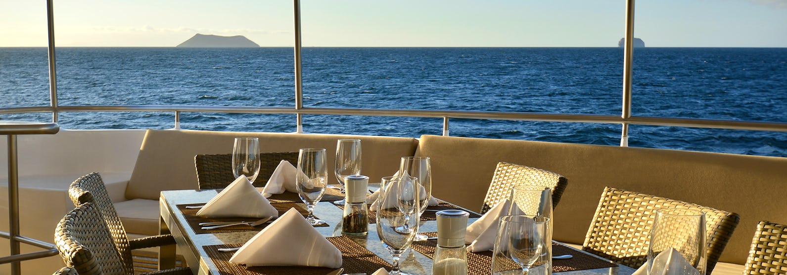 Bild på ett fint dukat bord ombord på Celebrity Xploration med det blåa havet i bakgrunden.