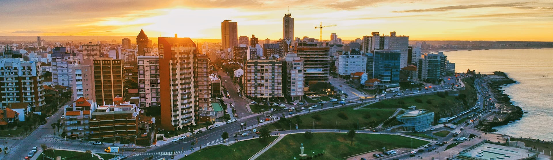 Bild på Buenos Aires kustlinje i solnedgången med byggnader till vänster och havet till höger.