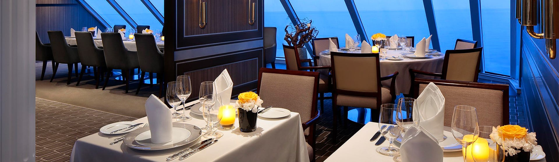 Bild från en av Azamara Quest lyxiga restauranger med stora fönster med utsikt över det blå havet.