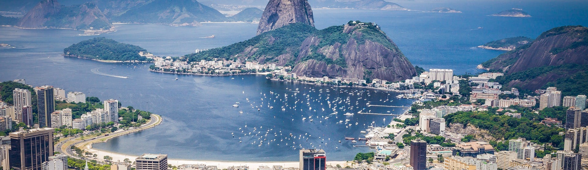 Bild ovanifrån på Rio de Janeiro i Brasilien med höga hus, stranden, berg och lagunen.