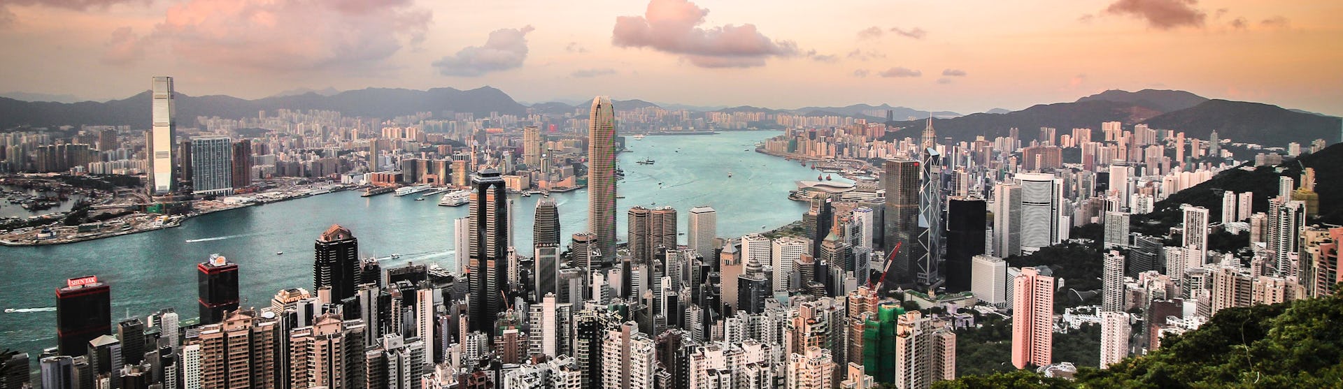 Bild på Victoria Harbour i Hong Kong tagen från luften med havet som skär mellan höghusen.