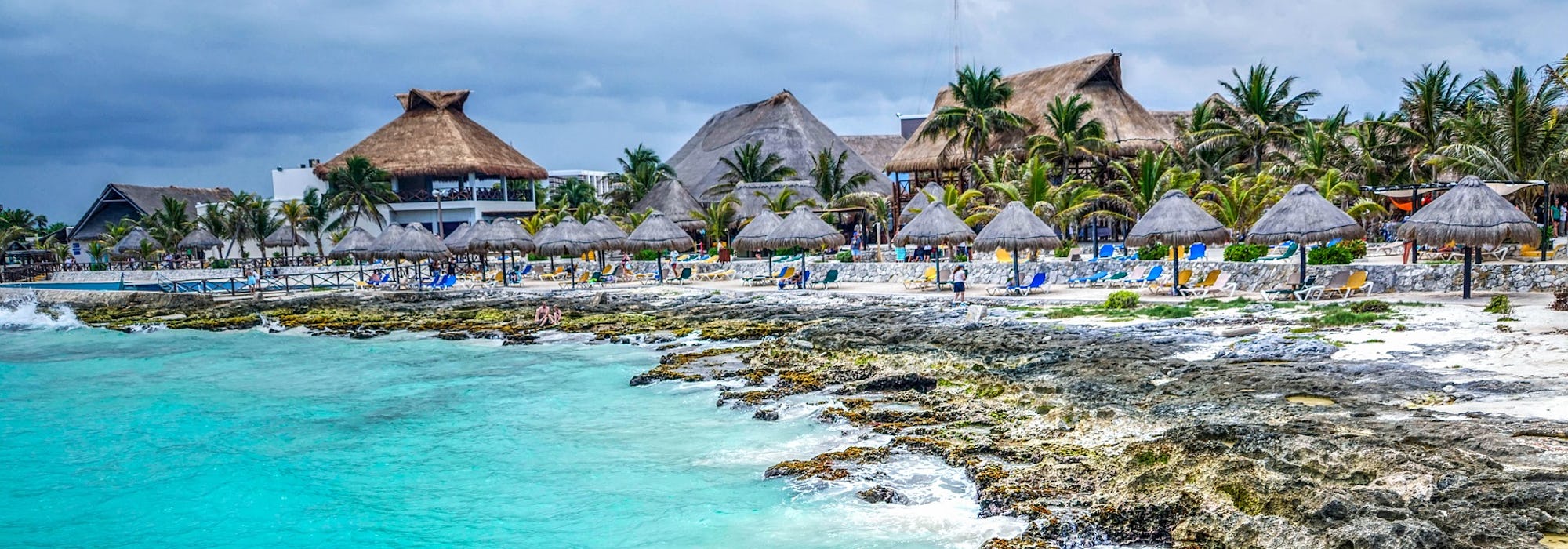 Bild på Costa Maya med klart vatten, klippor och palmer.
