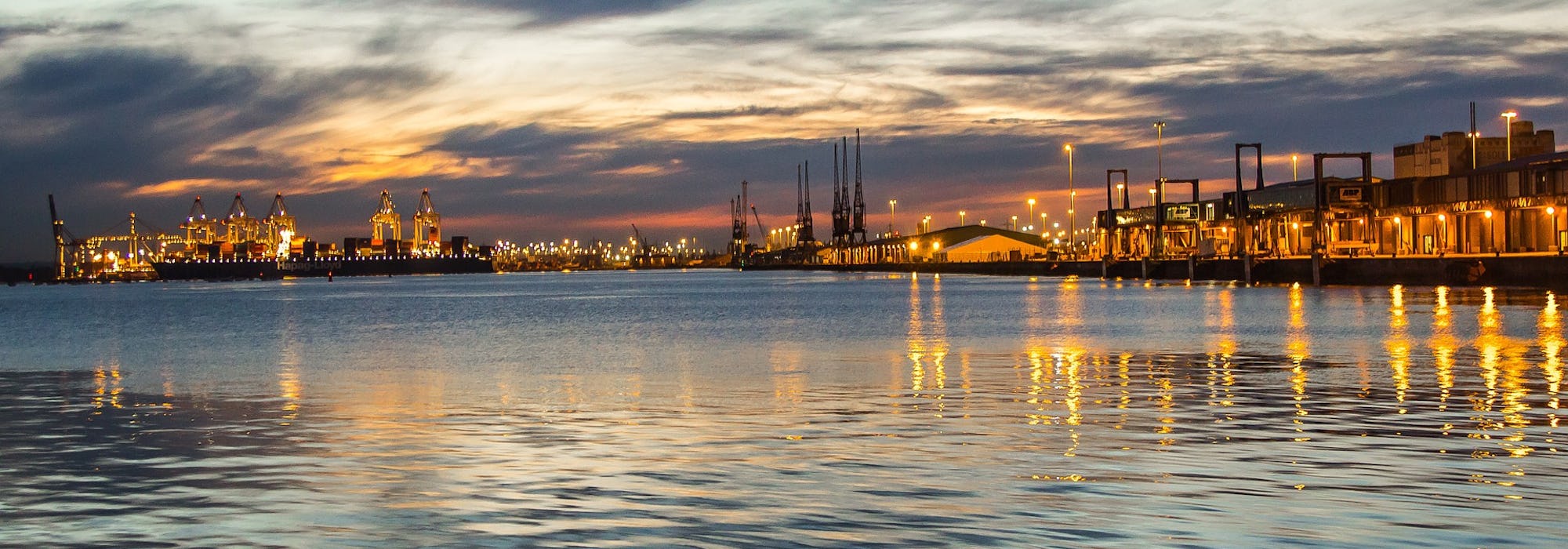 Southamptons hamn  i solnedgången med vattnet framför.