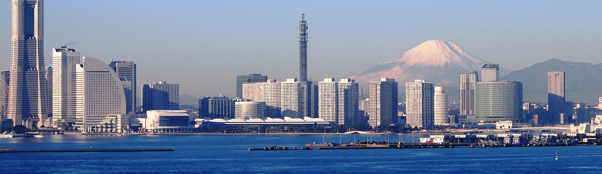 Bild på Yokohama med havet, höga byggnader och Mount Fuji i bakgrunden.