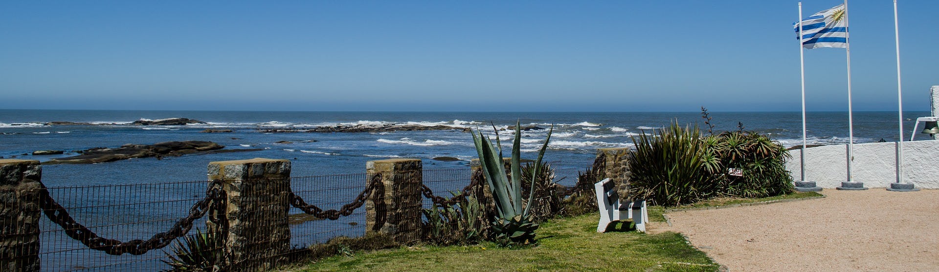 Montevideos kustlinje med havet och flaggan för Uruguay som vajar till höger.