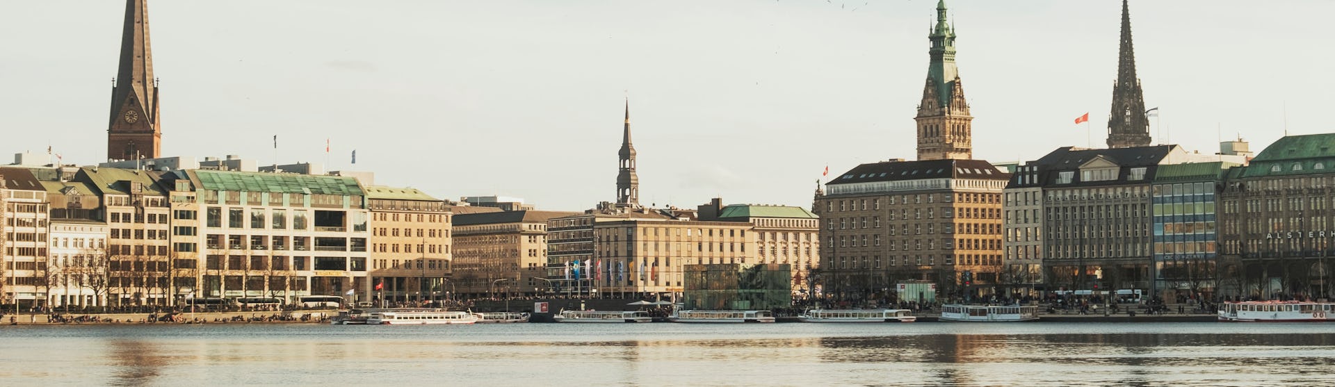 Bild på Hamburg med havet i förgrunden och byggnader i bakgrunden.