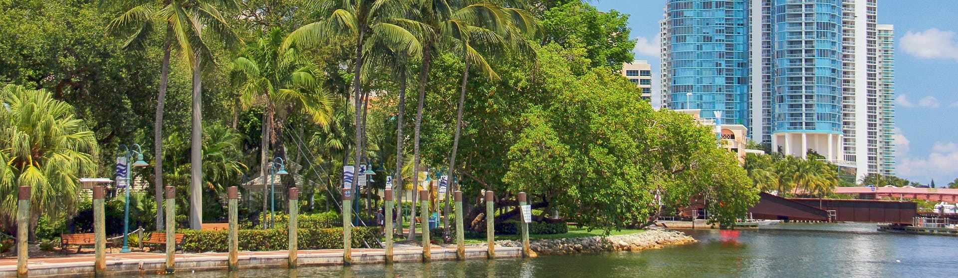 Fort Lauderdale med havet i nedkant, palmer och ett vitt och blått höghus till höger i bild.